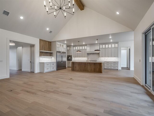 6201 Canopy Ln, Edmond, OK 73025 - kitchen with built in fridge, high vaulted ceiling, light countertops, a chandelier, and beamed ceiling