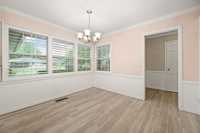 3222 Wilshire Ter, Oklahoma City, OK 73116 - empty room featuring a chandelier, crown molding, healthy amount of natural light, light wood-style floors, and wainscoting