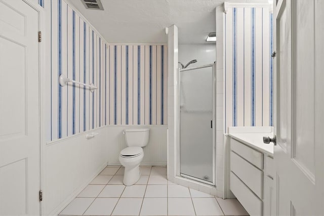 3222 Wilshire Ter, Oklahoma City, OK 73116 - bathroom featuring wallpapered walls, a shower stall, toilet, wainscoting, and tile patterned floors