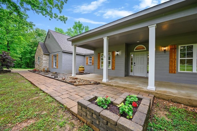 rear view of house featuring a porch and a shingled roof