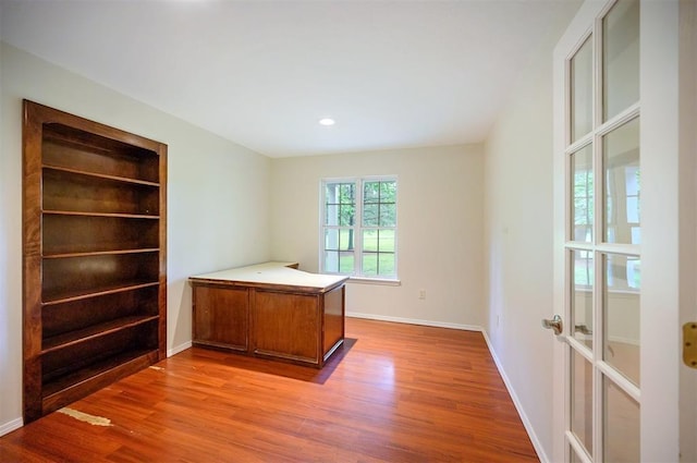 unfurnished office with wood finished floors, baseboards, and recessed lighting