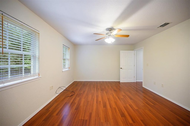 unfurnished room featuring wood finished floors, a ceiling fan, and baseboards