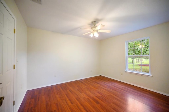 unfurnished room with a ceiling fan, wood finished floors, and baseboards