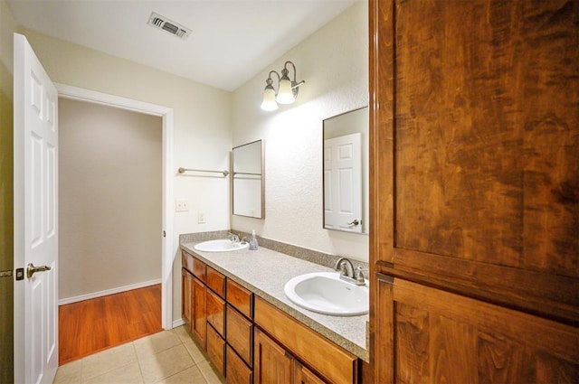 bathroom with tile patterned floors, double vanity, and baseboards