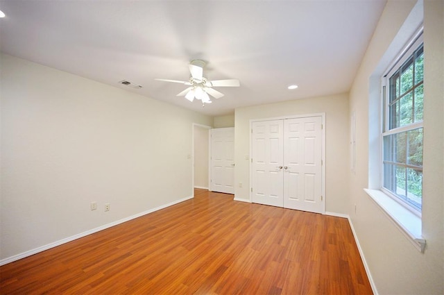 unfurnished bedroom with baseboards, wood finished floors, recessed lighting, a closet, and a ceiling fan