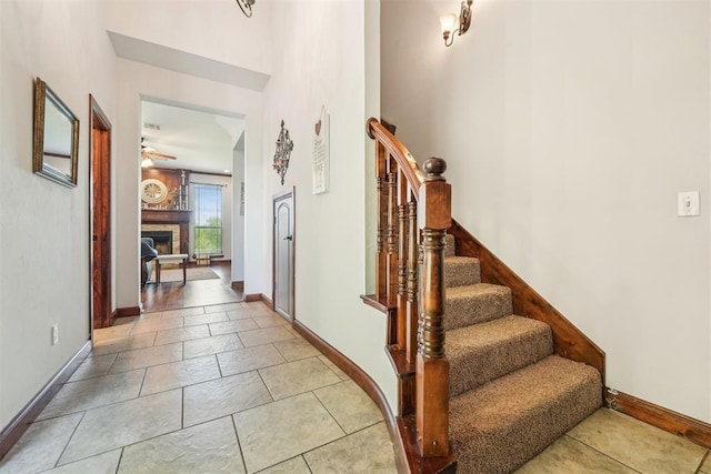 18421 State Highway 24, Purcell, OK 73080 - entryway with a fireplace, ceiling fan, stairway, baseboards, and light tile patterned flooring
