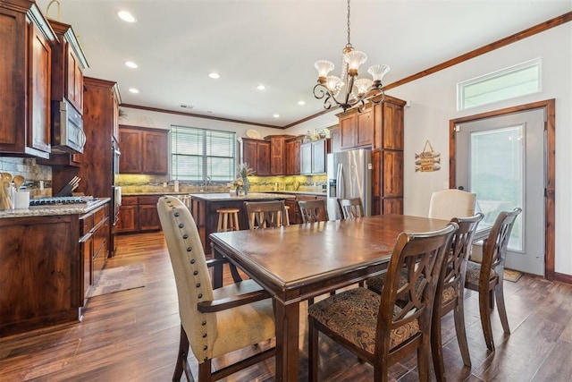 18421 State Highway 24, Purcell, OK 73080 - dining area with crown molding, a chandelier, dark wood-type flooring, and recessed lighting