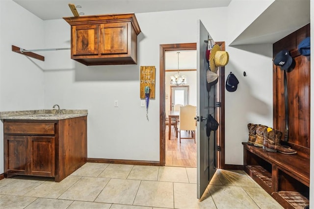 18421 State Highway 24, Purcell, OK 73080 - laundry room featuring baseboards, light tile patterned floors, and a chandelier