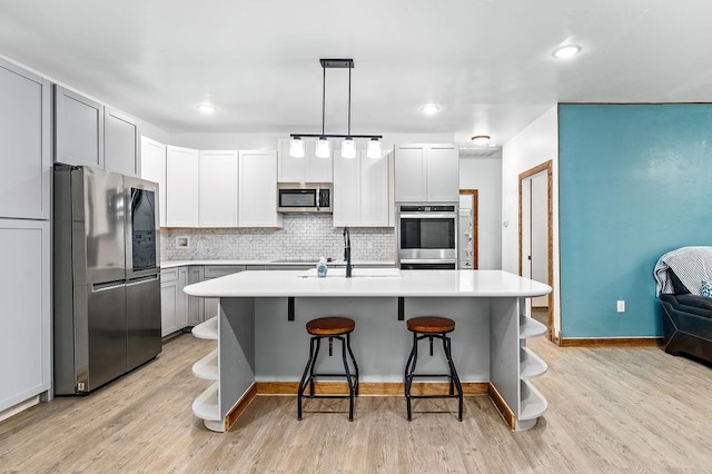 kitchen featuring stainless steel appliances, open shelves, a sink, light countertops, and decorative backsplash