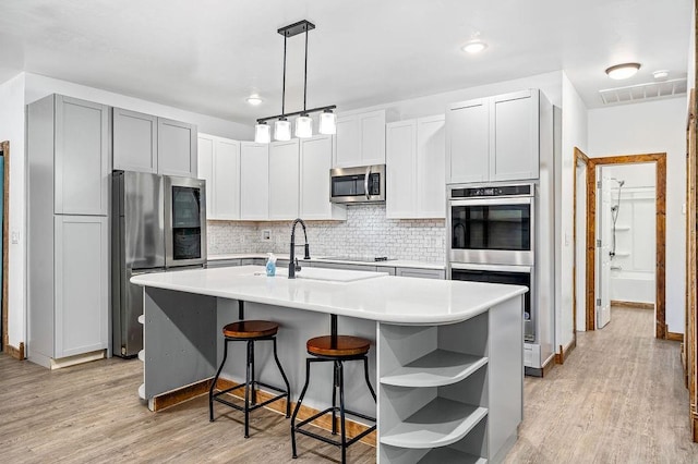 502 W Pine St, Tuttle, OK 73089 - kitchen featuring appliances with stainless steel finishes, open shelves, a sink, decorative backsplash, and light countertops