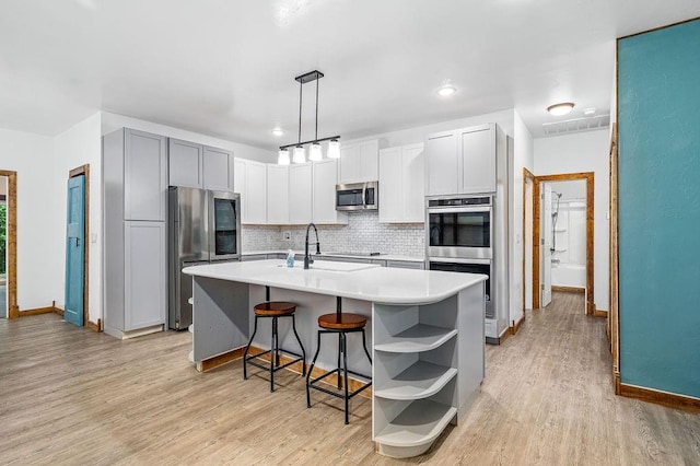 502 W Pine St, Tuttle, OK 73089 - kitchen featuring stainless steel appliances, open shelves, tasteful backsplash, baseboards, and light countertops