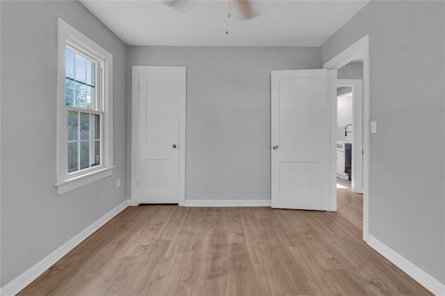 503 W Martin St, El Reno, OK 73036 - unfurnished bedroom with light wood-style flooring, baseboards, and ceiling fan