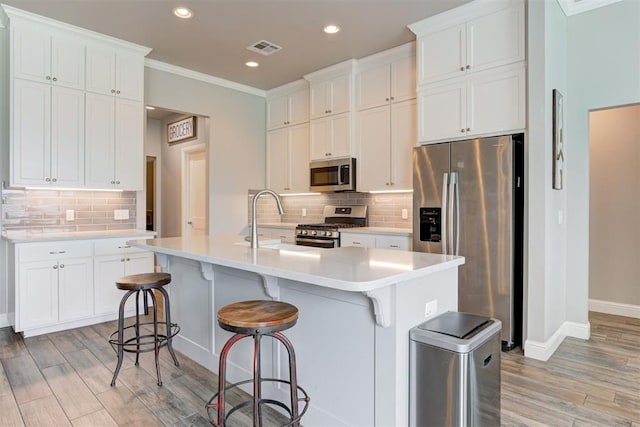 18337 Tombstone Trl, Norman, OK 73072 - kitchen featuring stainless steel appliances, light wood-type flooring, backsplash, recessed lighting, and light countertops