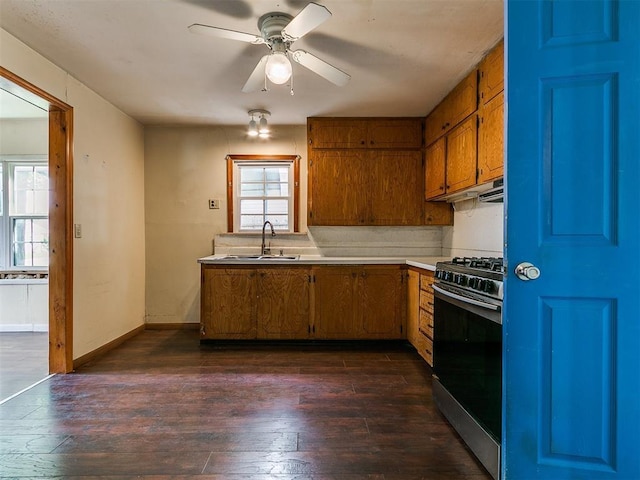 3617 N Westmont St, Oklahoma City, OK 73118 - kitchen featuring gas range, a sink, light countertops, brown cabinets, and dark wood-style flooring