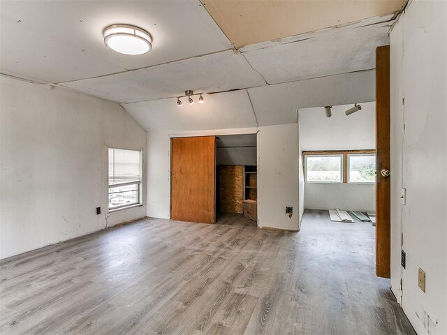 3617 N Westmont St, Oklahoma City, OK 73118 - unfurnished bedroom with multiple windows, lofted ceiling, wood finished floors, and a closet
