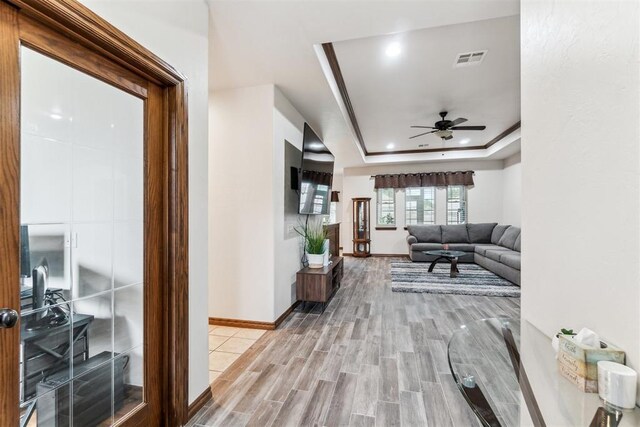 11423 Village Ave, Midwest City, OK 73130 - hallway with light wood-type flooring, a raised ceiling, baseboards, and recessed lighting