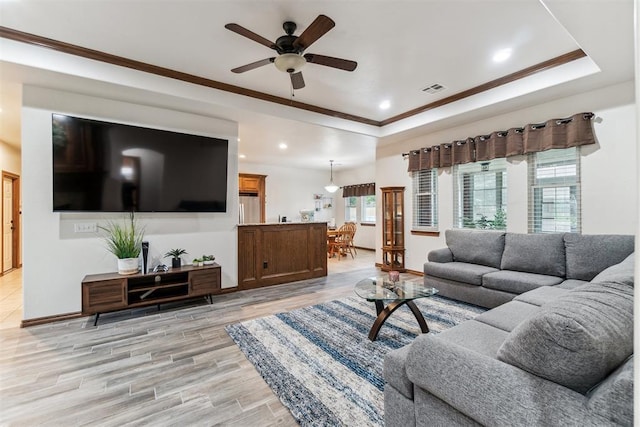 11423 Village Ave, Midwest City, OK 73130 - living area with a ceiling fan, plenty of natural light, a raised ceiling, light wood-type flooring, and ornamental molding