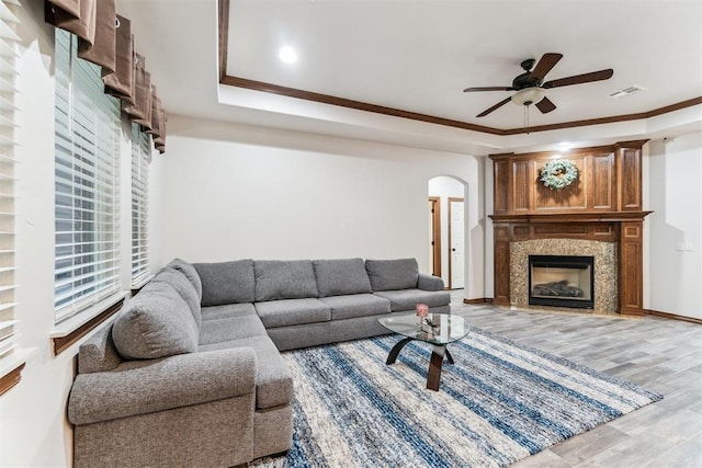 11423 Village Ave, Midwest City, OK 73130 - living room featuring a fireplace, ceiling fan, arched walkways, light wood-style floors, and crown molding