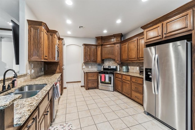 11423 Village Ave, Midwest City, OK 73130 - kitchen with appliances with stainless steel finishes, a sink, tasteful backsplash, light stone countertops, and light tile patterned floors