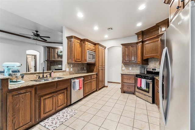 11423 Village Ave, Midwest City, OK 73130 - kitchen featuring stainless steel appliances, arched walkways, a sink, tasteful backsplash, and recessed lighting