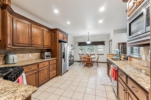 11423 Village Ave, Midwest City, OK 73130 - kitchen featuring appliances with stainless steel finishes, a sink, decorative backsplash, light tile patterned floors, and light stone counters