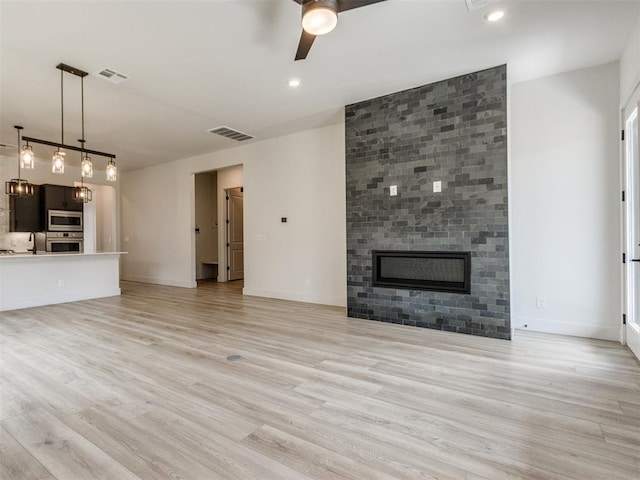 8916 NW 130th St, Oklahoma City, OK 73142 - unfurnished living room featuring ceiling fan, a large fireplace, light wood-style floors, baseboards, and recessed lighting