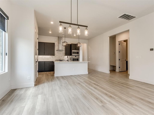 8916 NW 130th St, Oklahoma City, OK 73142 - kitchen with wall chimney exhaust hood, stainless steel appliances, plenty of natural light, light wood-style flooring, and recessed lighting