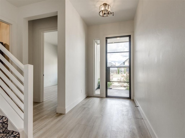 8916 NW 130th St, Oklahoma City, OK 73142 - doorway to outside featuring light wood-style flooring, stairs, baseboards, and a chandelier
