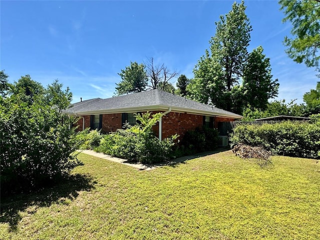 202 Flanders Dr, Chickasha, OK 73018 - view of property exterior with a yard, brick siding, and roof with shingles
