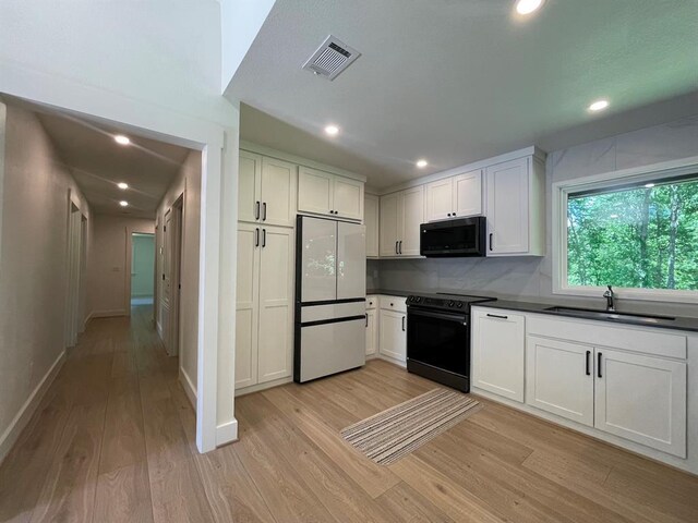 1920 Glover Golden Rd, Broken Bow, OK 74728 - kitchen with black appliances, dark countertops, light wood finished floors, a sink, and recessed lighting