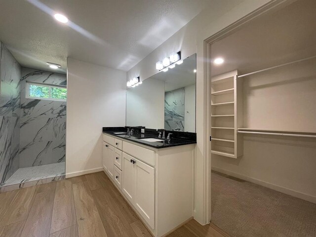 1920 Glover Golden Rd, Broken Bow, OK 74728 - bathroom with a marble finish shower, baseboards, double vanity, wood finished floors, and recessed lighting