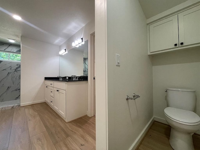 1920 Glover Golden Rd, Broken Bow, OK 74728 - bathroom featuring wood finished floors, toilet, vanity, baseboards, and walk in shower