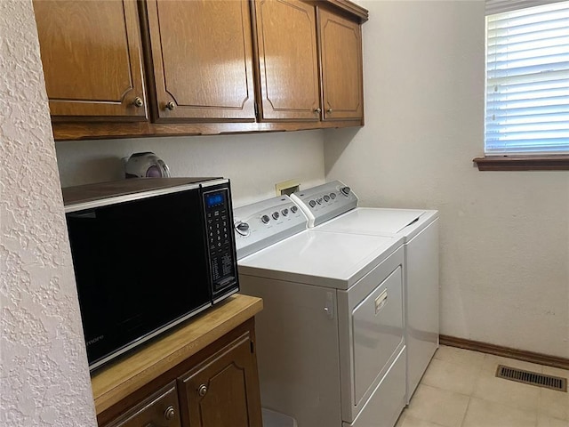 laundry room with washing machine and clothes dryer, cabinet space, and baseboards