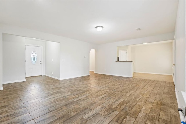 9801 Ashley Pl, Oklahoma City, OK 73120 - unfurnished living room with wood finished floors, arched walkways, and baseboards