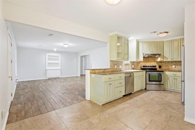 9801 Ashley Pl, Oklahoma City, OK 73120 - kitchen with stainless steel appliances, backsplash, a sink, and under cabinet range hood