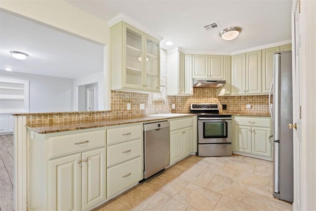 9801 Ashley Pl, Oklahoma City, OK 73120 - kitchen with appliances with stainless steel finishes, a sink, under cabinet range hood, decorative backsplash, and light stone countertops