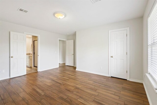 9801 Ashley Pl, Oklahoma City, OK 73120 - unfurnished bedroom featuring wood finished floors, baseboards, and multiple windows