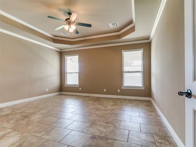 spare room featuring a tray ceiling, plenty of natural light, crown molding, ceiling fan, and baseboards
