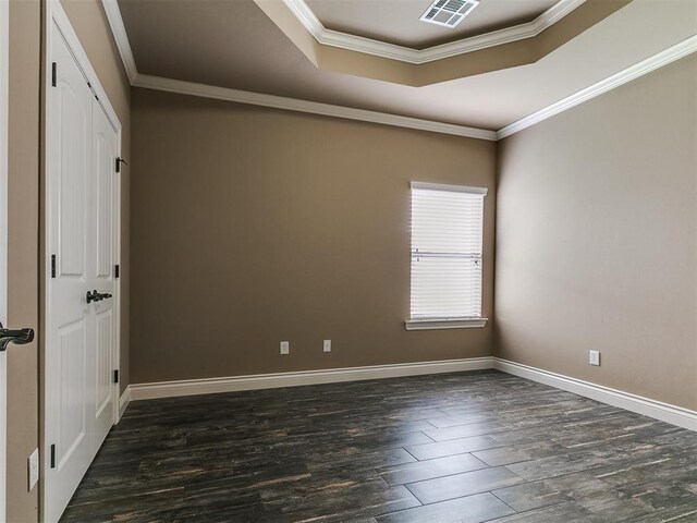 spare room featuring crown molding, dark wood-style flooring, baseboards, and a tray ceiling