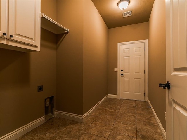 clothes washing area with hookup for an electric dryer, cabinet space, and baseboards