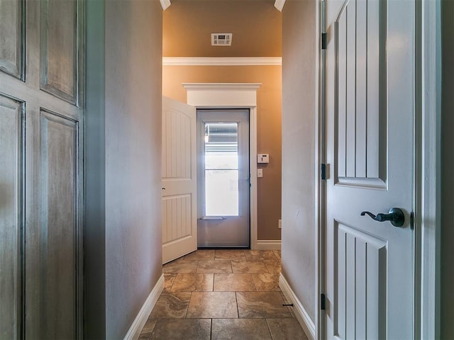 doorway featuring baseboards and crown molding