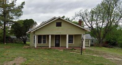1318 S 16th St, Chickasha, OK 73018 - view of front of house featuring covered porch, a front lawn, and a chimney