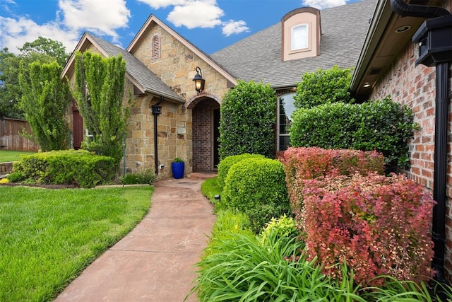1401 Canyon Bridge Ln, Edmond, OK 73034 - view of front of property featuring stone siding, roof with shingles, and a front lawn