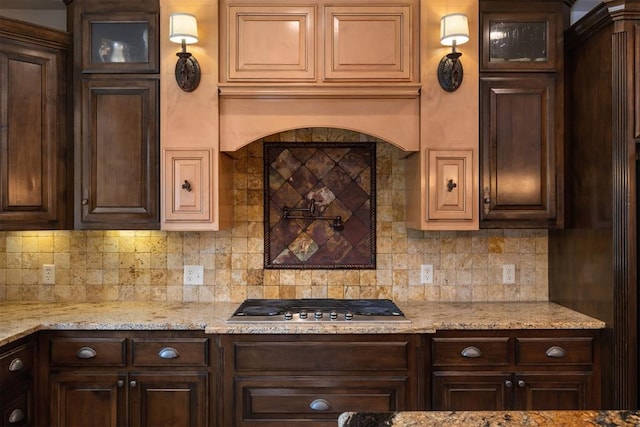 1401 Canyon Bridge Ln, Edmond, OK 73034 - kitchen with stainless steel gas cooktop, dark brown cabinets, glass insert cabinets, and backsplash