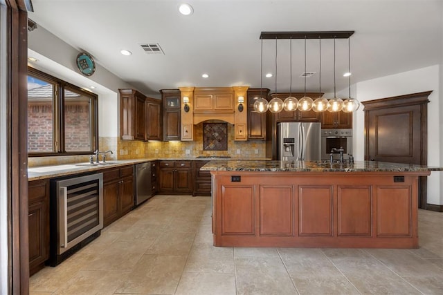 1401 Canyon Bridge Ln, Edmond, OK 73034 - kitchen with beverage cooler, appliances with stainless steel finishes, dark stone counters, decorative backsplash, and a sink