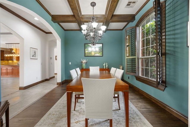 1401 Canyon Bridge Ln, Edmond, OK 73034 - dining space featuring a chandelier, arched walkways, wood finished floors, beam ceiling, and baseboards
