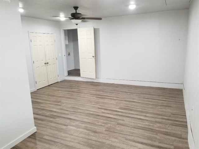 unfurnished room featuring ceiling fan, wood finished floors, and baseboards