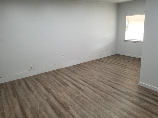 spare room featuring wood finished floors and baseboards