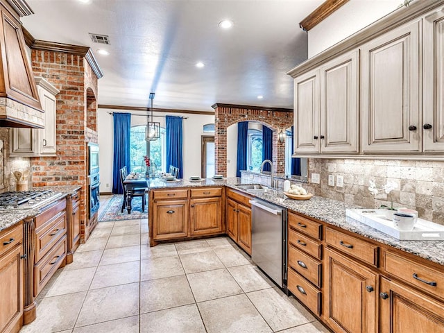 kitchen with stainless steel appliances, ornamental molding, a peninsula, tasteful backsplash, and light stone countertops