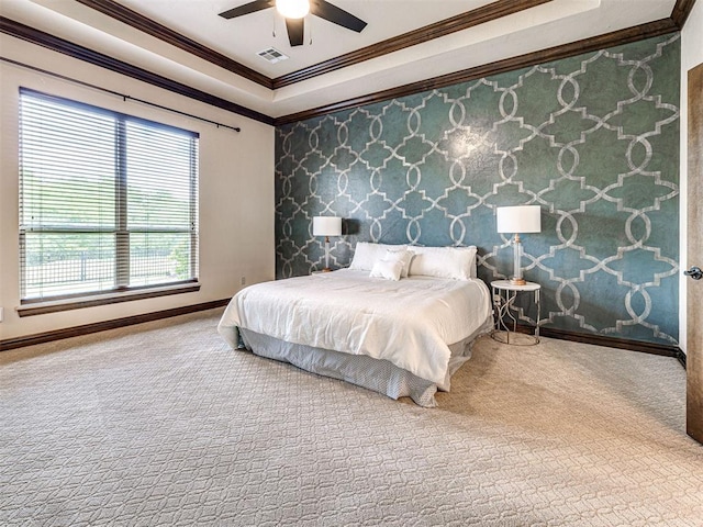 carpeted bedroom featuring crown molding, a tray ceiling, baseboards, ceiling fan, and wallpapered walls